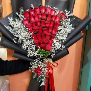 بوكيه هاند بجوري احمر وبيبي فلاور ابيض بلفه سودا وشريط احمر بيبي فلاور