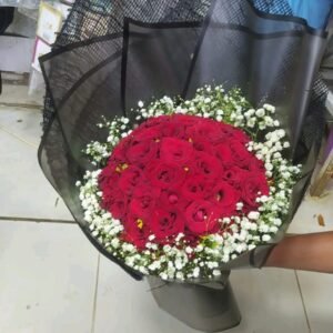 بوكيه هاند بجوري احمر وبيبي فلاور ابيض على شكل دائري بلفه سودا