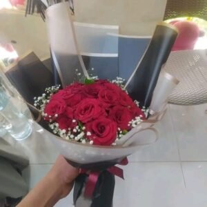 بوكيه هاند بورد جوري صناعي احمر وبيبي فلاور صناعي ابيض بفه سودا وشريط احمر